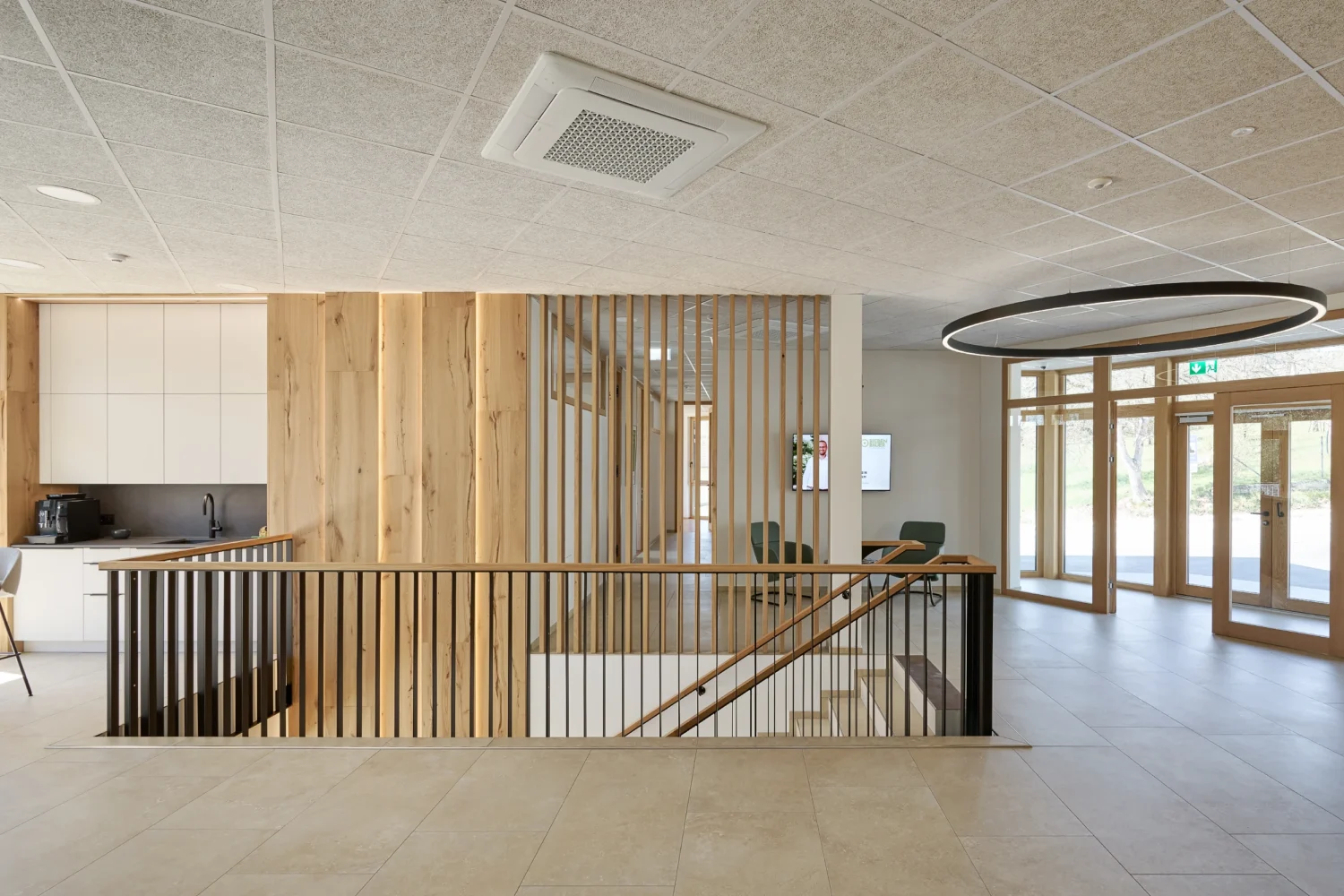 Foyer des Bürohauses Riebenbauer mit offener Treppe, vertikalen Holzlamellen und großzügiger Verglasung